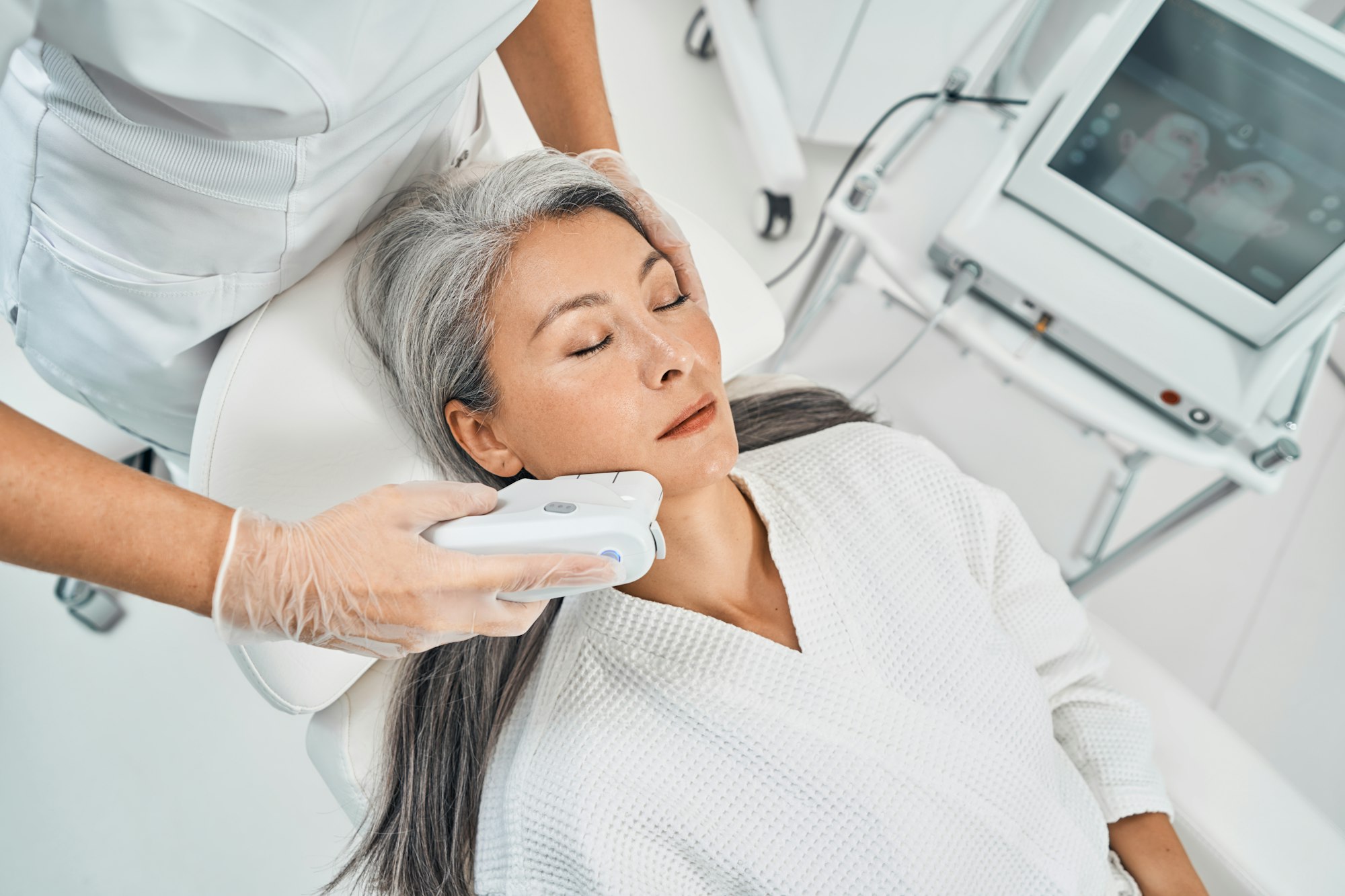 Focused photo on cosmetologist doing facial epilation