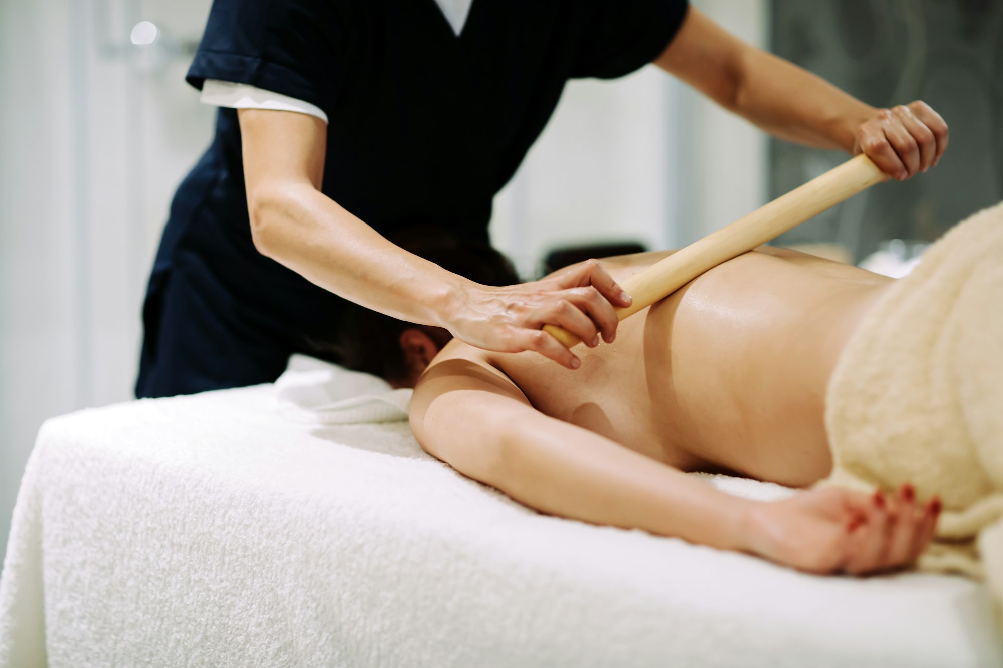 Masseur treating patient with therapeutic massage