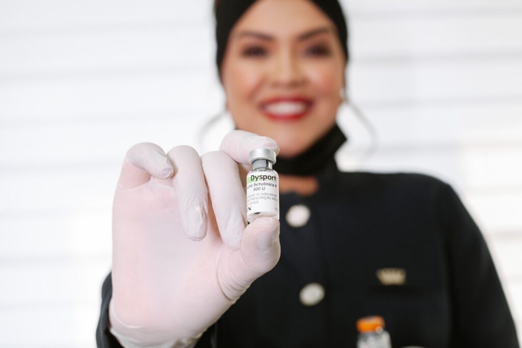Medical professional holding a vial of Dysport injectable treatment for cosmetic wrinkle reduction.