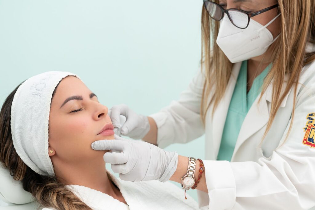 Licensed medical professional performing a facial skin evaluation before an aesthetic treatment in a cosmetic clinic.