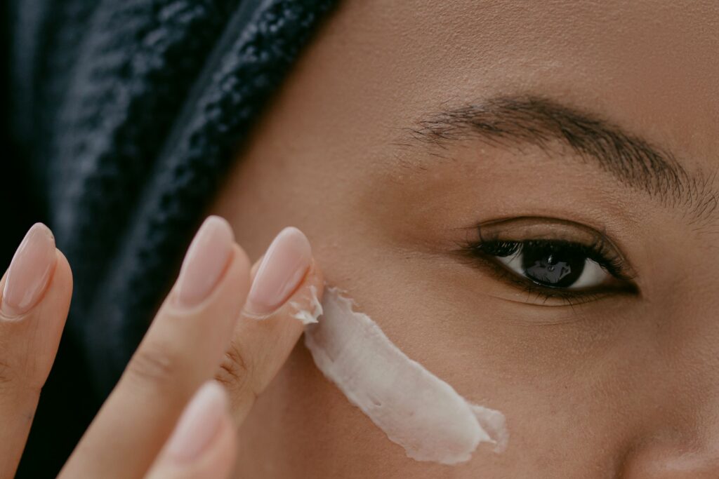 Close-up of a person applying moisturizing eye cream to the under-eye area as part of a daily skincare routine.