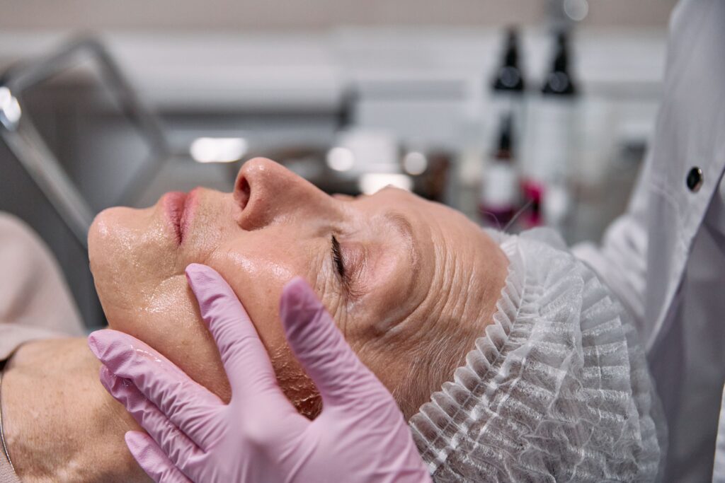 Medical provider evaluating a patient's facial contours before dermal filler treatment.