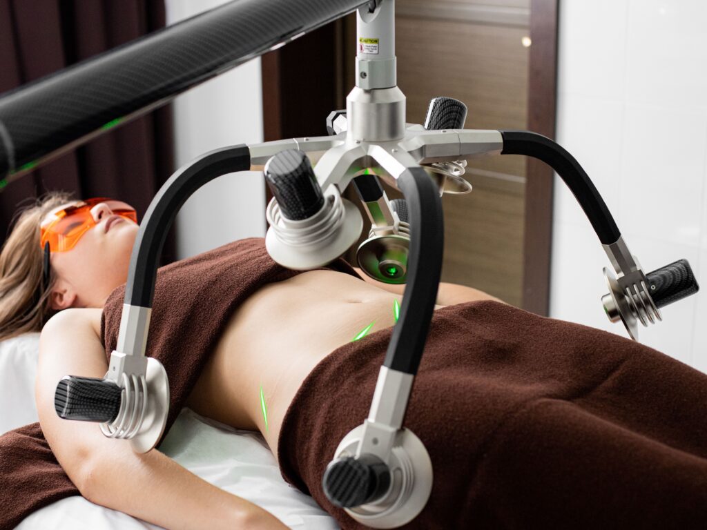 Patient receiving a non-invasive laser body contouring treatment for fat reduction and body sculpting.