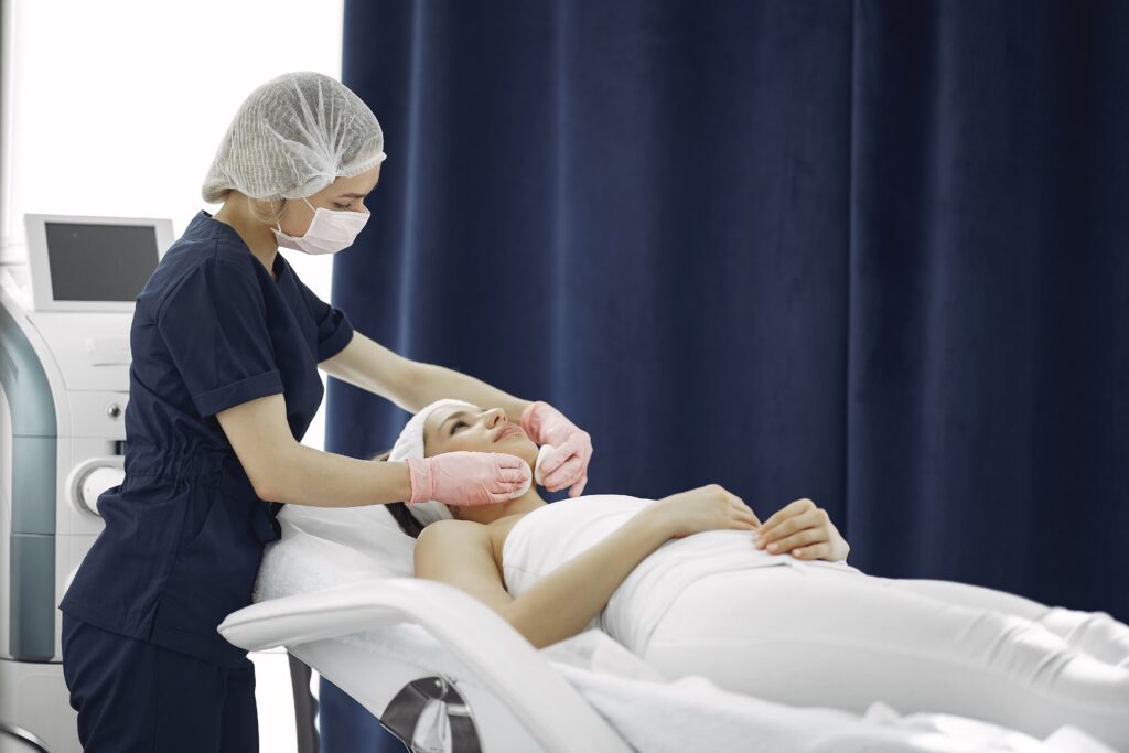 Licensed esthetician performing a professional facial examination before a skincare treatment in a modern medical spa.