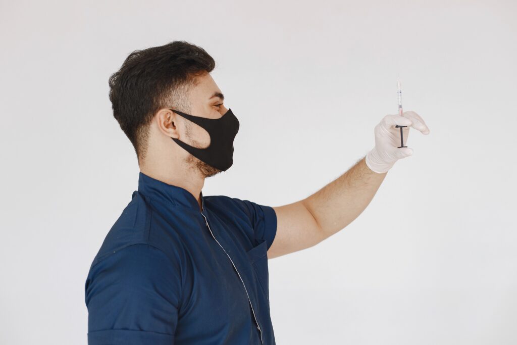Medical professional holding a syringe prepared for an injectable aesthetic treatment in a cosmetic clinic.
