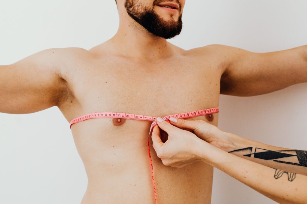 Male patient having chest measurements taken during a body contouring consultation or cosmetic treatment assessment.