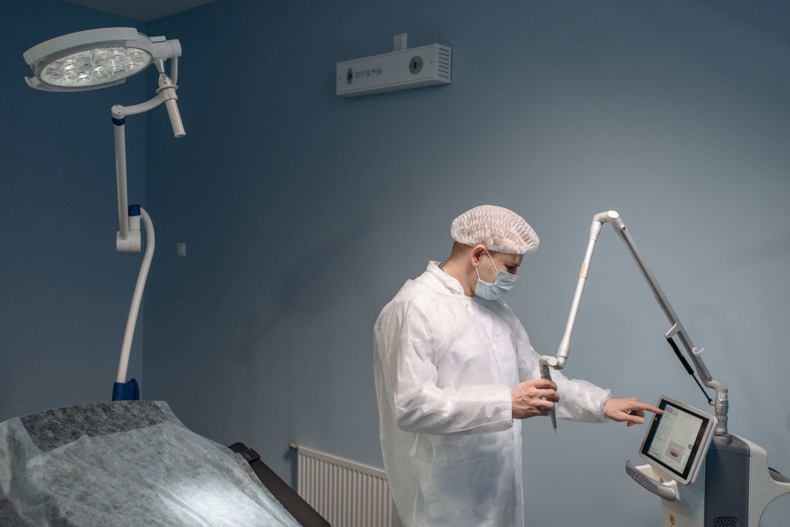 Medical professional preparing advanced laser equipment for a cosmetic skin rejuvenation treatment.