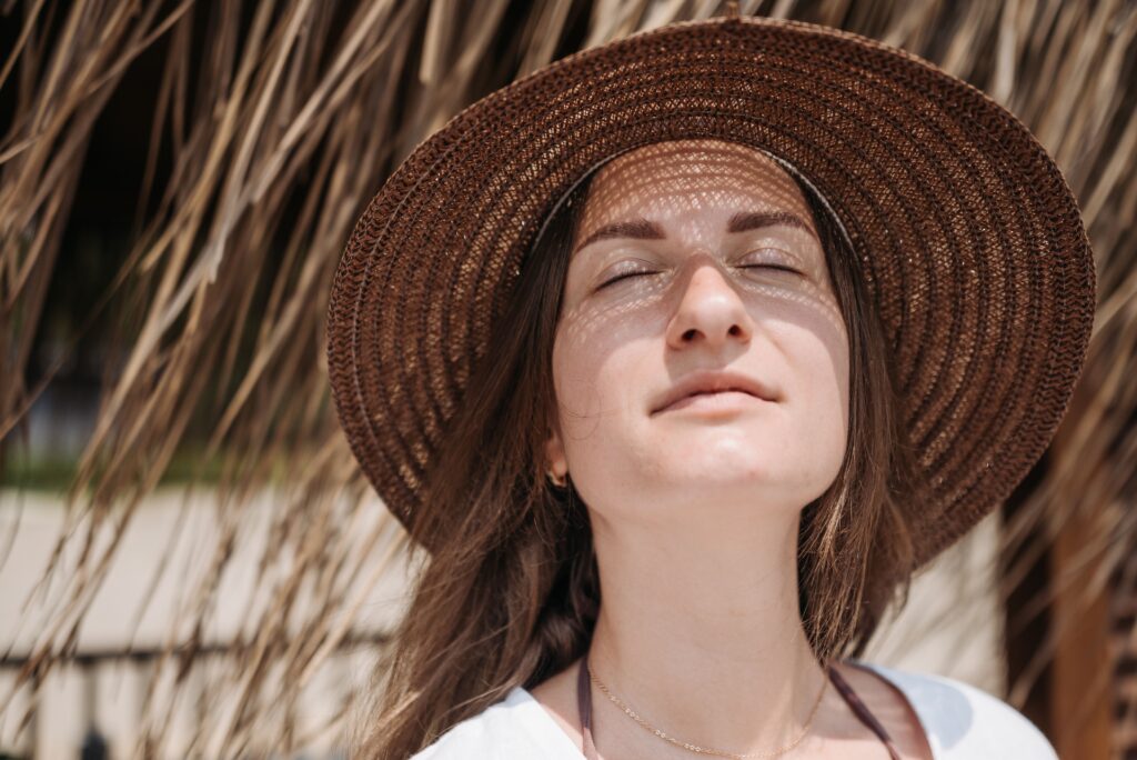 Woman wearing a wide-brim sun hat to protect her skin from harmful UV rays.