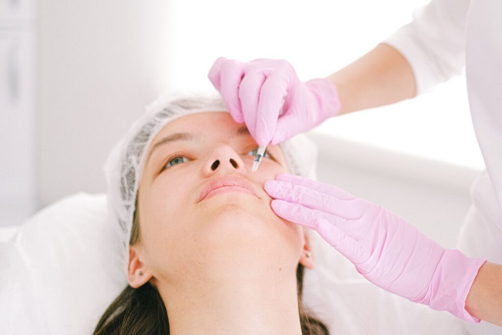 Medical professional performing a cosmetic facial injection to reduce fine lines and improve facial appearance.