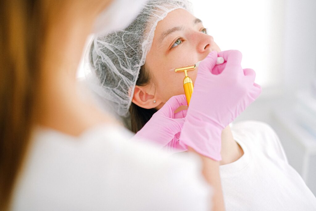 Aesthetic provider performing a gold microneedling facial treatment to improve skin texture and stimulate collagen production.